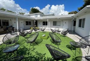 un gruppo di sedie seduti sull'erba in un cortile di Awesome Studio 15 min from The Beach a Miami