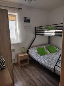 sypialnia z łóżkiem piętrowym i zielonymi poduszkami w obiekcie Idylla w mieście Połom Mały