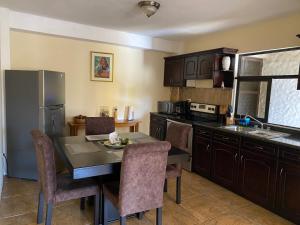 a kitchen with a table and chairs and a refrigerator at Apartamento #2 Portal de Occidente in Quetzaltenango