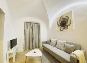 a living room with a couch and a tv at Apartamento Turístico Marem Cáceres in Cáceres