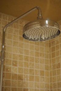 baño con ducha y azulejos marrones en Boutique Hotel De Brakelhoen en Brakel