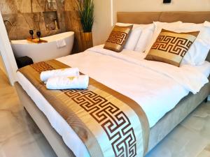 1 dormitorio con 1 cama con sábanas y almohadas blancas en Rose Suite en Caesarea