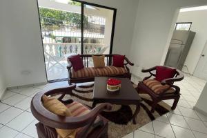 a living room with two chairs and a table at Hermosa y acogedora casa Familiar como te mereces in San Felipe de Puerto Plata