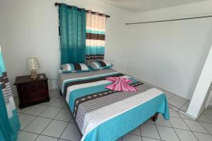 um quarto com uma cama com um laço rosa em Hermosa y acogedora casa Familiar como te mereces em San Felipe de Puerto Plata
