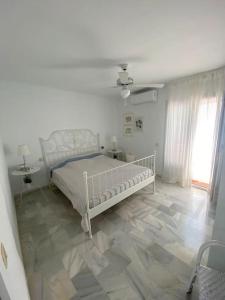 Habitación blanca con cama y ventana en AMR Lomos Blancos, en Mojácar