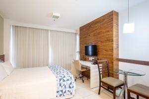 Habitación de hotel con cama y escritorio en Flat fusion 16 + garagem, en Brasilia