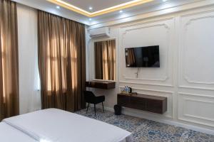 una camera d'albergo con letto e televisore a parete di Ardani hotel,Samarqand a Khodzha-Akhrar