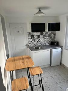 a kitchen with two stools and a sink at L'hippo-gîte in Fressenneville