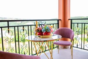 a table with a bowl of flowers on a balcony at Piano & Gold Collections, Peduase in Peduasi