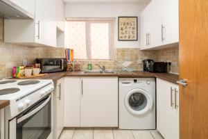 a kitchen with a washing machine and a sink at 2 bedroom flat near London ExCel in London