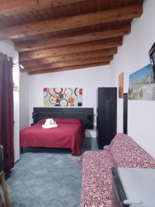 a bedroom with a red bed and a couch at Villa Lucia in Lampedusa