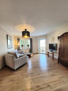 a living room with a couch and a tv at Ahrtal Vier Sterne Ferienwohnungen Alexandra Weiler Ferienwohnung Harmonie in Bad Neuenahr-Ahrweiler