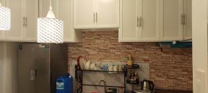 a kitchen with white cabinets and a brick wall at Lakeshore Villa in San Benito +2 photos