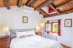 Schlafzimmer mit einem weißen Bett und Holzdecken in der Unterkunft Duca Di Dolle in Rolle