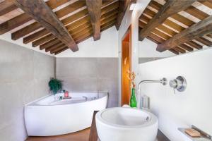 ein Badezimmer mit einer großen Badewanne und einem Waschbecken in der Unterkunft Duca Di Dolle in Rolle
