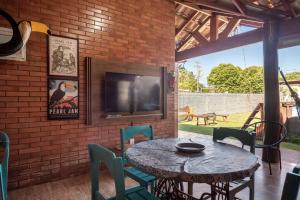 patio con mesa, sillas y TV en Casa Victour, localização privilegiada, en Bonito