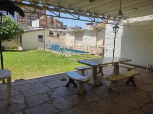 una mesa de picnic y bancos en un patio en Casa en Carlos Paz en Villa Carlos Paz