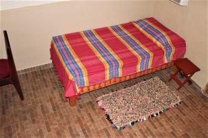 - un lit avec une couverture colorée et un tapis dans l'établissement Cabañas Rústicas El Benny by Rotamundos, à Loreto