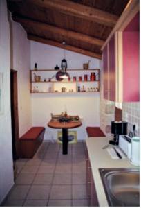 a kitchen with a table and a sink in it at Villa Belvedere - Sea view apts near Banana beach in Vasilikos