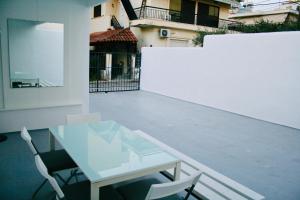een witte tafel en stoelen op een balkon bij REM House in Thessaloniki