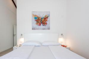 a white bedroom with a butterfly painting on the wall at Villa Stella - heated pool, jacuzzi & sauna in Šibenik +68 photos