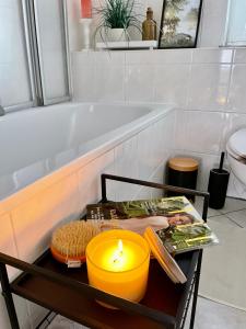 uma vela sobre uma mesa na casa de banho com uma banheira em Visit_Oberhof em Oberhof
