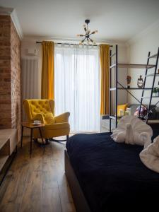 a bedroom with a bed and a yellow chair at Brick House - Apartament Zośka in Wrocław