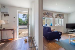Yew Tree Cottage في Westleton: غرفة معيشة مع أريكة زرقاء وتلفزيون