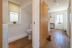 a bathroom with a toilet and a window at Yew Tree Cottage in Westleton +17 photos