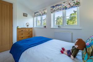 a child sitting on a bed in a bedroom at Yew Tree Cottage in Westleton
