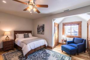 a bedroom with a bed and a blue chair at Modern Mountain Lodge Oasis w Hot Tub-Rio Grande Trail in Carbondale