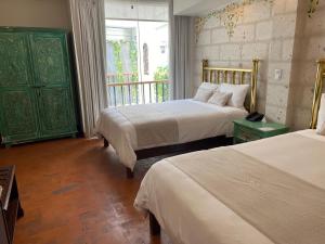 Habitación de hotel con 2 camas y ventana en Katari Hotel at Plaza de Armas, en Arequipa