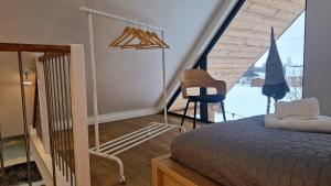a bedroom with a bed and a chair and a window at Brzuchem do góry in Chocieszow