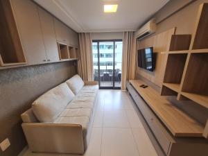 a living room with a couch and a tv at HOLANDAS PRIME TAMBAU Flat in João Pessoa