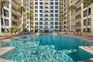 una piscina frente a un gran edificio de apartamentos en “Lotusland” Origin at Seahaven! en Panama City Beach