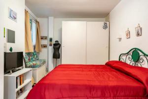 1 dormitorio con 1 cama roja y 1 silla en Loft incantevole all'obelisco en Roma