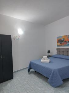 a bedroom with two beds and a painting on the wall at Villa Lucia in Lampedusa