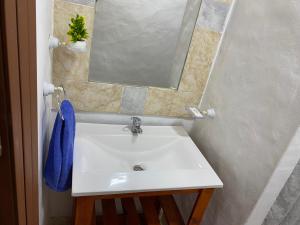 lavabo con espejo y toalla azul en Departamentos Cachita en Carhué