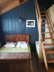 Un dormitorio con una cama con paredes azules y una escalera en Gîte la ferme de Baffour, en La Chaise-Dieu