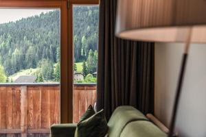 a room with a couch and a window with a view at Ciasa Agreiter in La Villa +3 photos