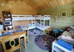 a room with bunk beds and a table and a dining room at Satukurki-vierasmaja - Simple and Cute Cabin in Sastamala