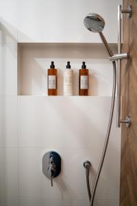 a bathroom with three bottles on a shelf at Brick House - Apartament Zośka in Wrocław