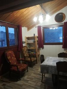 sala de estar con mesa, sillas y ventana en Gîte la ferme de Baffour, en La Chaise-Dieu