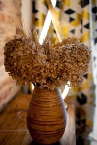 a vase filled with dried flowers sitting on a table at Brick House Premium Apartments in Wrocław