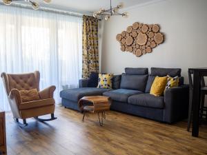 a living room with a blue couch and a chair at Brick House - Apartament Zośka in Wrocław