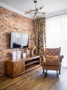 a living room with a television on a brick wall at Brick House Premium Apartments in Wrocław