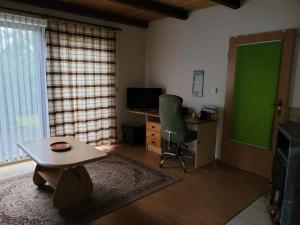 Habitación con puerta verde, escritorio y silla en Ferienhaus Gappa, en Bad Wilsnack