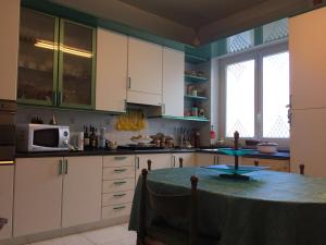 a kitchen with white cabinets and a table in it at B&B DONNA PORZIA in Trani +12 photos