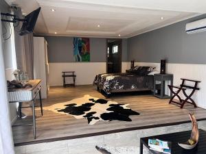 a bedroom with a cow rug on the floor at Inaki Uhi Hotel in Hanga Roa