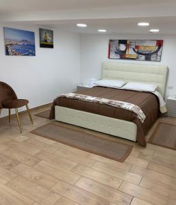 1 dormitorio con 1 cama grande y 1 silla en b&b la corte in centro en Caserta